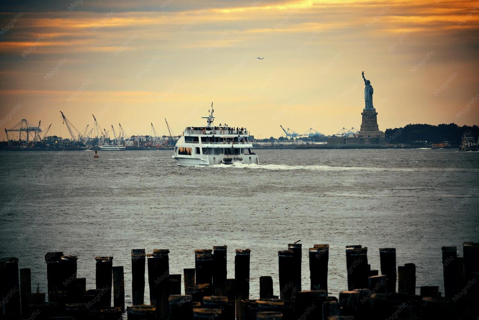 The Staten Island Ferry crossing New York Harbor past the Statue of Liberty at sunset