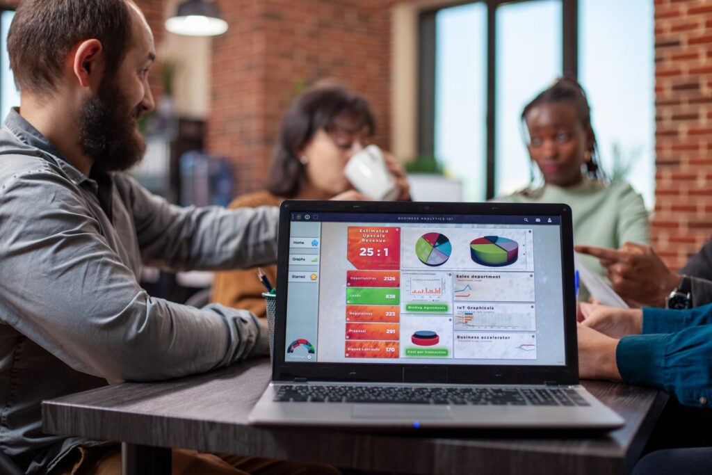 Marketing team reviewing ad campaign analytics on a laptop