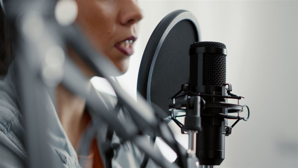 Podcast host speaking into a microphone in a studio